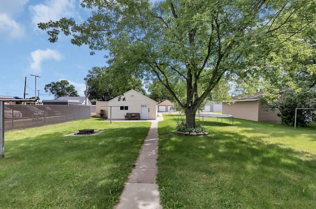 view of yard featuring an outbuilding and a trampoline