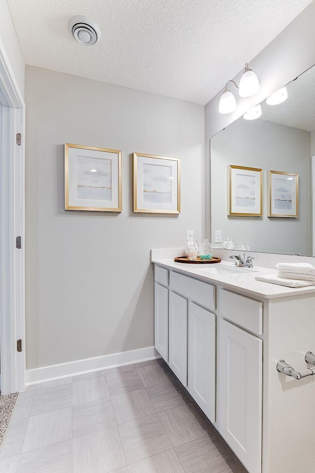 bathroom with a textured ceiling and vanity