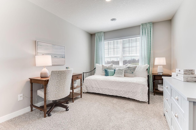 bedroom with light colored carpet and a textured ceiling