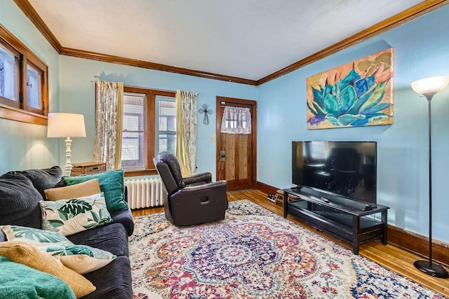 living room with hardwood / wood-style flooring, ornamental molding, and radiator heating unit