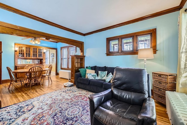 living room with radiator, hardwood / wood-style flooring, ornamental molding, and ceiling fan