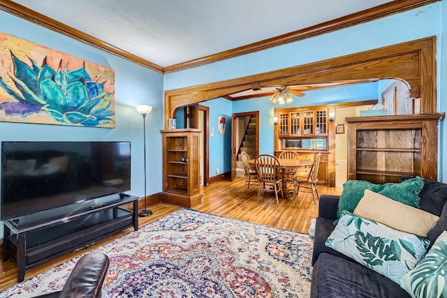 living room with crown molding, ceiling fan, and hardwood / wood-style flooring