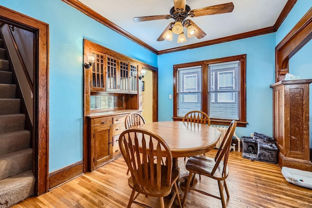 dining space with crown molding, ceiling fan, and light wood-type flooring