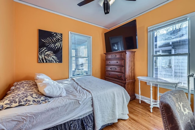 bedroom featuring crown molding, wood-type flooring, and ceiling fan