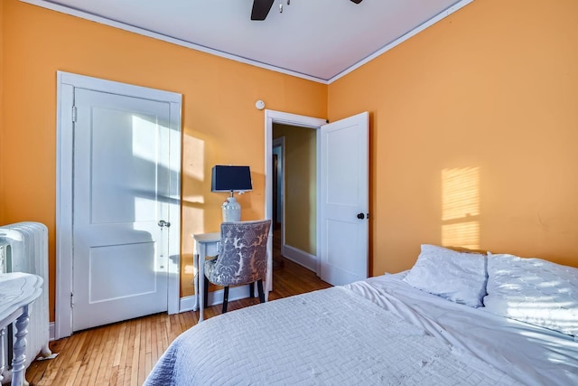 bedroom featuring hardwood / wood-style floors, radiator heating unit, and ceiling fan