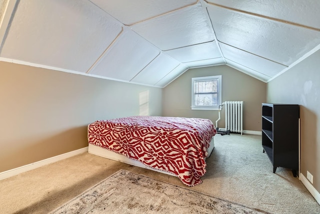 carpeted bedroom with radiator heating unit, a textured ceiling, and vaulted ceiling