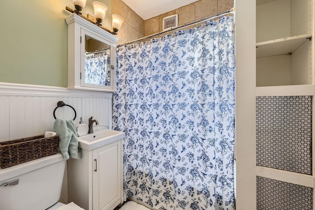 bathroom with walk in shower, vanity, and toilet