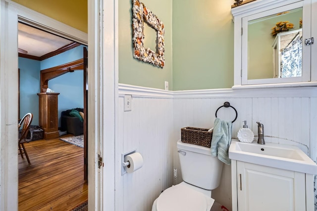 bathroom with vanity, crown molding, wood-type flooring, and toilet