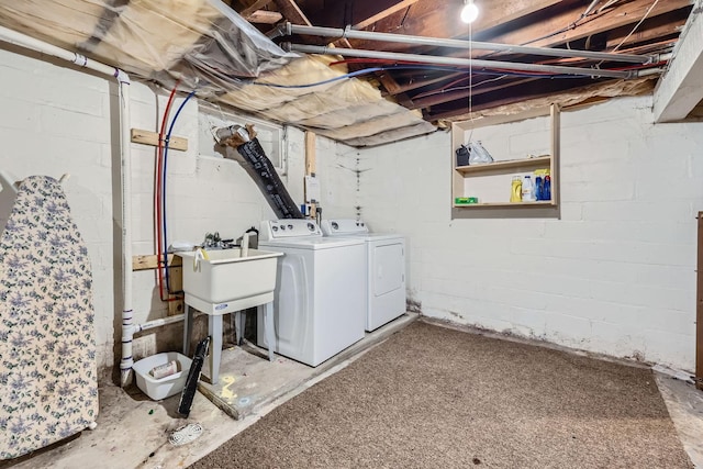 clothes washing area featuring separate washer and dryer and sink