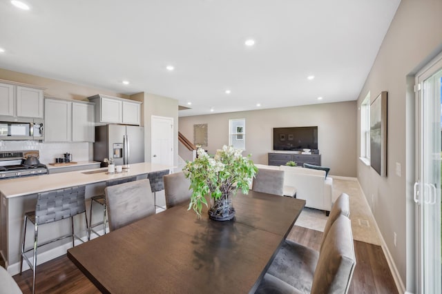 dining space featuring sink and dark wood-type flooring