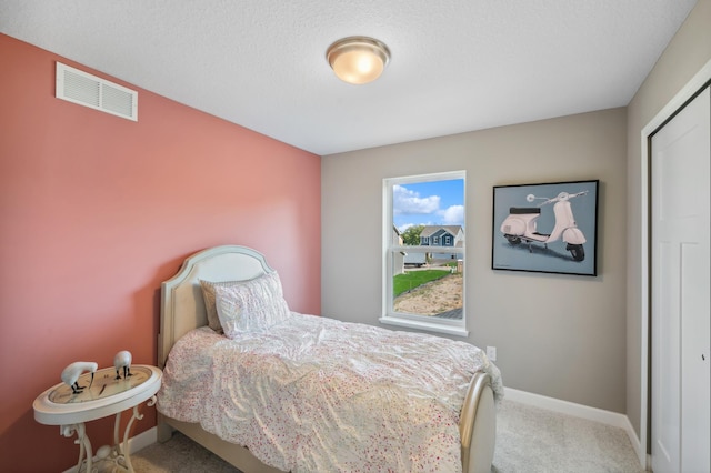 bedroom with carpet flooring and a textured ceiling