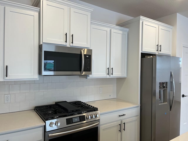 kitchen featuring white cabinetry, decorative backsplash, and stainless steel appliances