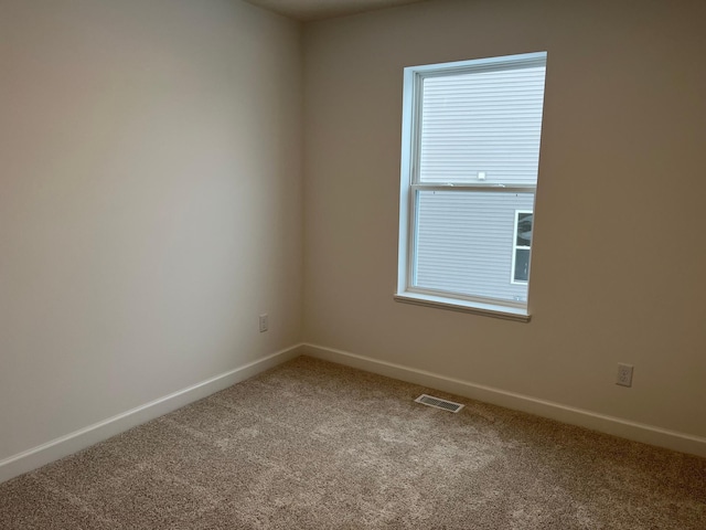 unfurnished room with a wealth of natural light and carpet