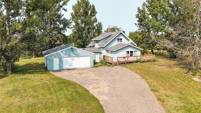 view of front facade featuring a garage, an outbuilding, a front yard, and a deck