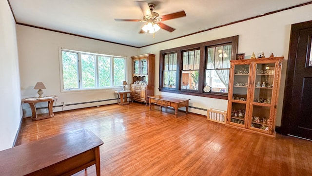 sitting room featuring wood-type flooring, a baseboard radiator, and ceiling fan