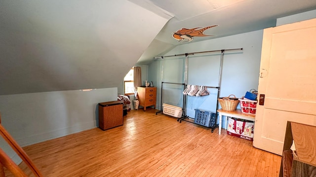 additional living space featuring vaulted ceiling and light hardwood / wood-style floors