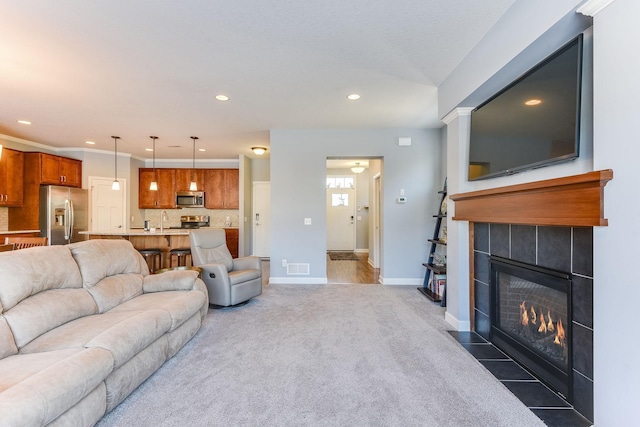 carpeted living room with sink and a fireplace