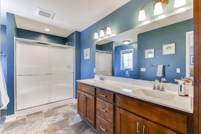 bathroom with vanity and a shower with shower door