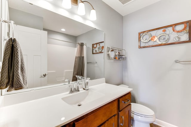 bathroom featuring vanity, curtained shower, and toilet