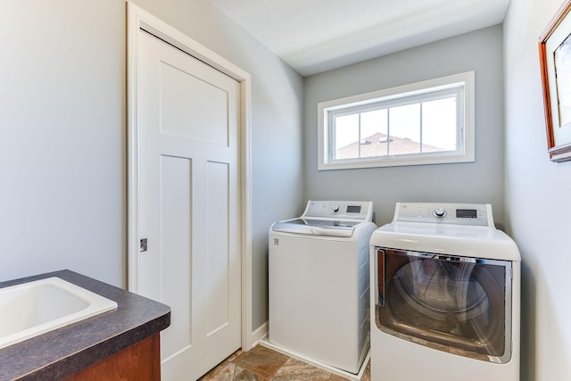 clothes washing area featuring washer and clothes dryer and sink