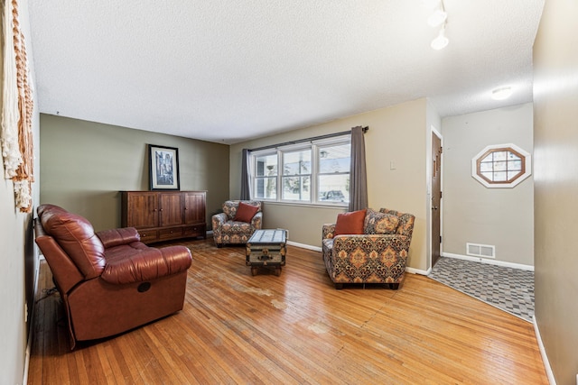 living room with wood-type flooring and a textured ceiling