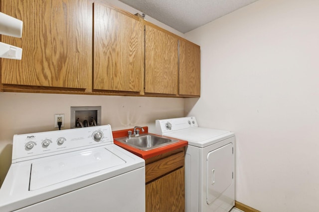 laundry area with sink, independent washer and dryer, cabinets, and a textured ceiling