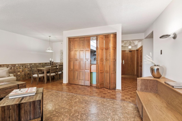 interior space with a textured ceiling and parquet flooring