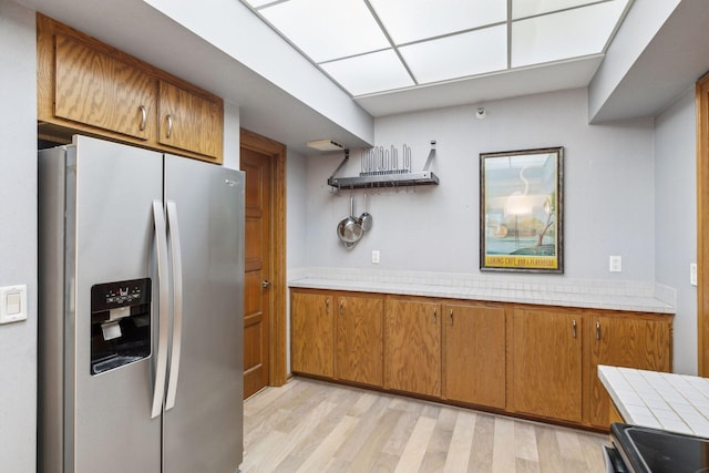 kitchen featuring light hardwood / wood-style floors, appliances with stainless steel finishes, and tile counters