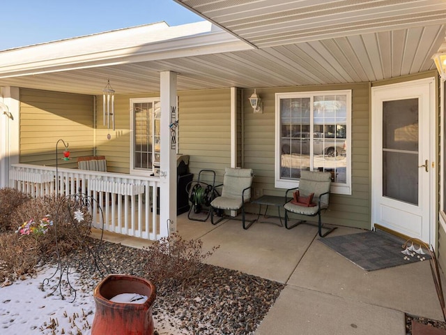 snow covered patio with a porch