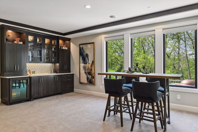 carpeted dining area featuring bar area and wine cooler