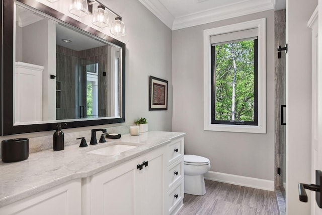 bathroom with toilet, walk in shower, ornamental molding, and vanity