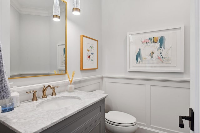 bathroom featuring toilet, vanity, and crown molding