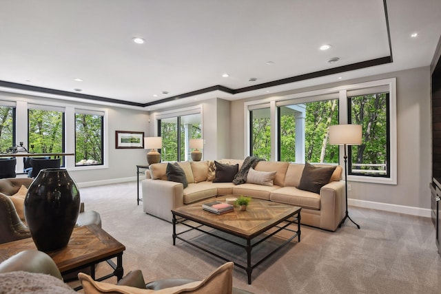 carpeted living room with crown molding and a tray ceiling