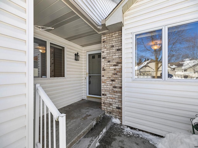 view of exterior entry featuring brick siding