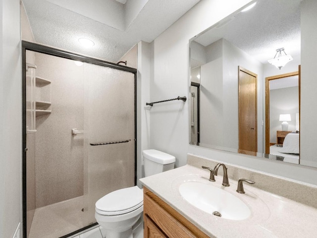 bathroom featuring a stall shower, toilet, vanity, and a textured ceiling