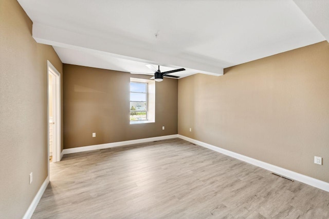 spare room with ceiling fan, beam ceiling, and light wood-type flooring