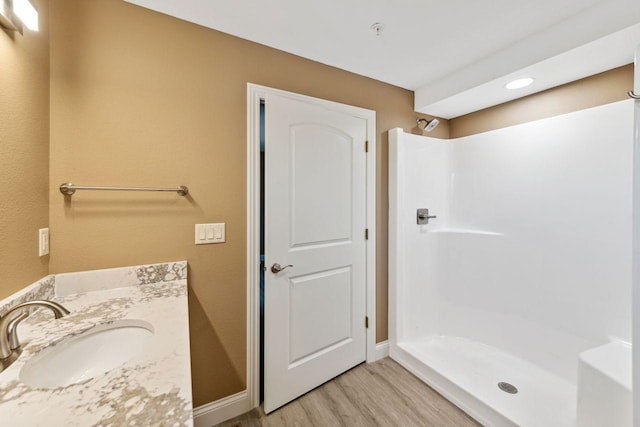 bathroom featuring vanity, hardwood / wood-style flooring, and walk in shower