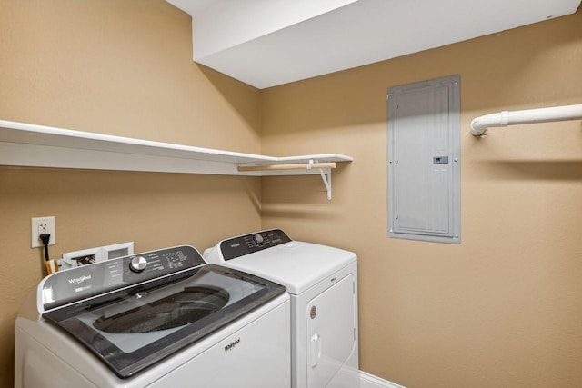 clothes washing area with electric panel and separate washer and dryer