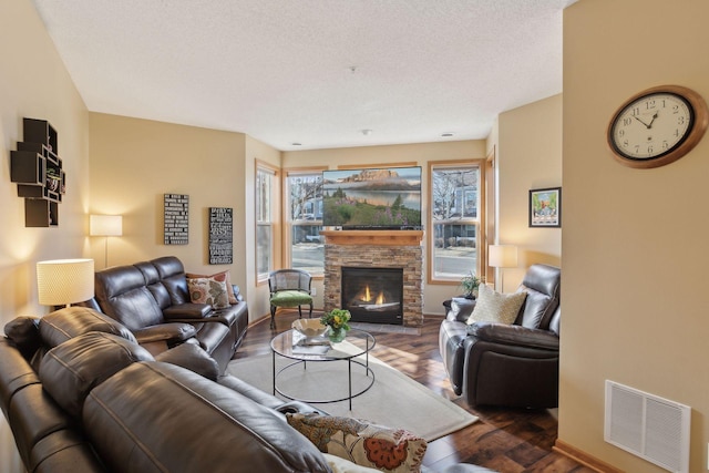 living room featuring dark hardwood / wood-style flooring, a fireplace, and a textured ceiling