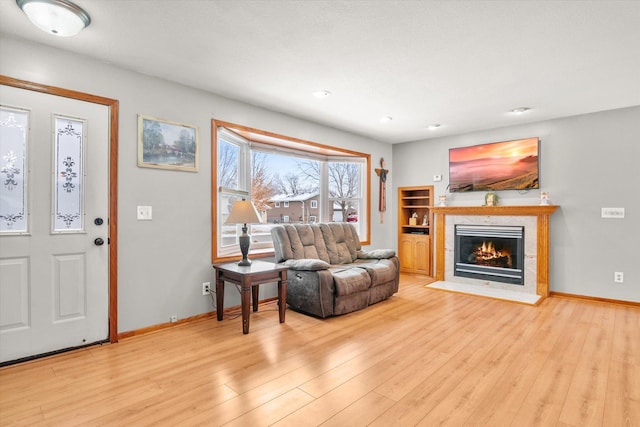 interior space featuring a tiled fireplace and light hardwood / wood-style flooring