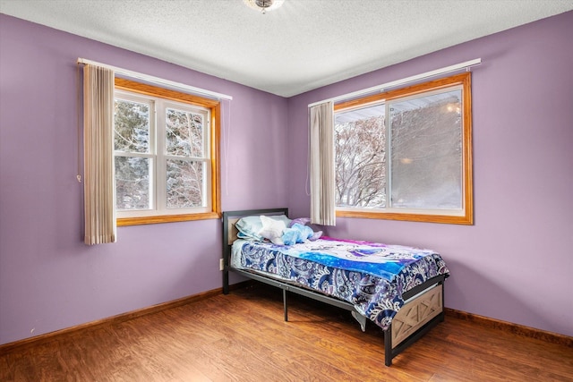 bedroom with hardwood / wood-style flooring and a textured ceiling