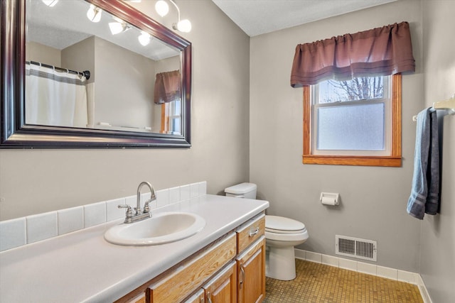 bathroom with tile patterned flooring, vanity, and toilet