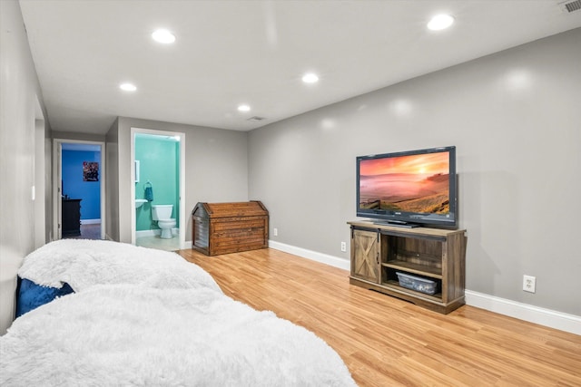 bedroom with hardwood / wood-style flooring and ensuite bath