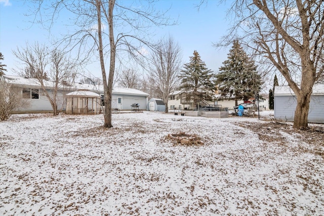 yard layered in snow featuring a storage shed