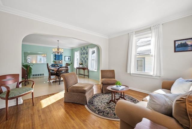 living room featuring arched walkways, hardwood / wood-style flooring, and crown molding