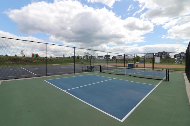 view of tennis court featuring basketball hoop