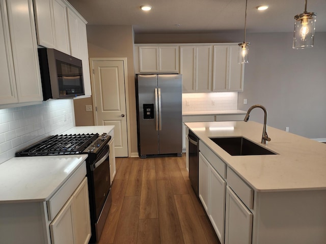 kitchen with sink, range with gas stovetop, stainless steel fridge with ice dispenser, and decorative light fixtures