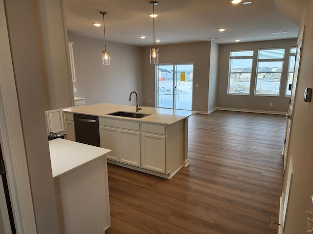 kitchen featuring decorative light fixtures, black dishwasher, sink, white cabinets, and a kitchen island with sink