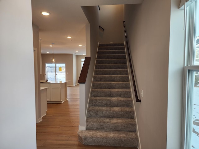 staircase featuring sink and wood-type flooring