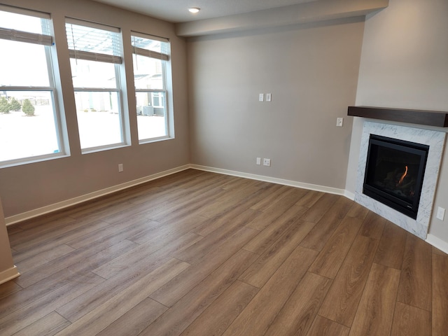 unfurnished living room featuring light hardwood / wood-style flooring and a premium fireplace